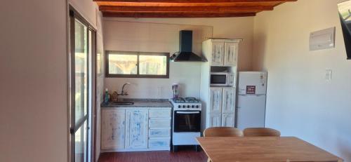 a kitchen with white appliances and a wooden table at Altos de Vella Bista in Bella Vista