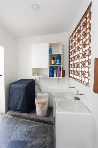 a white bathroom with a sink and a toilet at Espaço Sideral - Quartos com ar-condicionado, 5min Estádio Maracanã, 8min UERJ, shopping, 12min metrô, wi-fi 300mbp, ampla área comum com cozinha - prático e confortável in Rio de Janeiro
