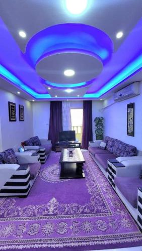a living room with purple furniture and a blue ceiling at water house in Al Quwaysimah