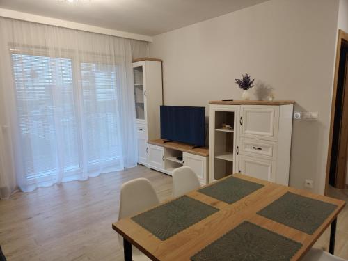 a dining room with a table and a television at Sweet Home Sielawy in Poznań