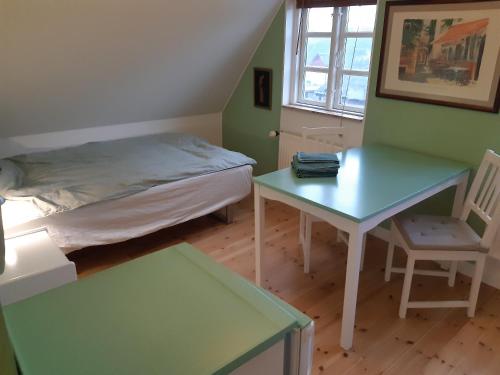 a bedroom with a bed and a table and a chair at Seneberg - Rooms for rent in Snertinge