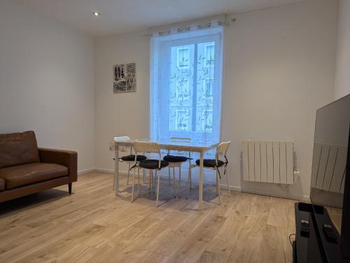 une salle à manger avec une table, des chaises et un canapé dans l'établissement Le Vauban - appartement 2 chambres, salon, cuisine équipée, parking et wifi gratuit, à Mulhouse