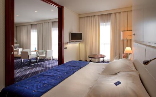 a hotel room with a large bed with a mirror at SH Valencia Palace in Valencia