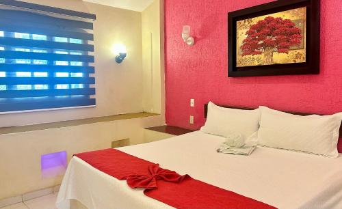 a bedroom with a bed with a red wall at Hotel Barranquilla in Campeche