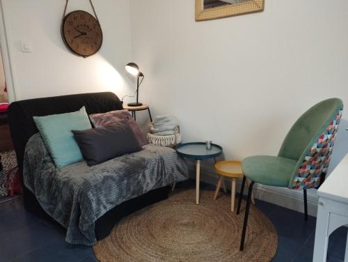 un salon avec un canapé et une chaise dans l'établissement Le St Romain Proche Bugey & Lyon, à Saint-Romain-de-Jalionas