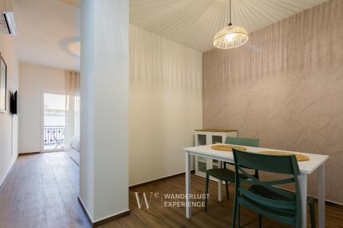 a dining room with a table and green chairs at Wanderlust Experience Le dimore di Alice in Bitonto