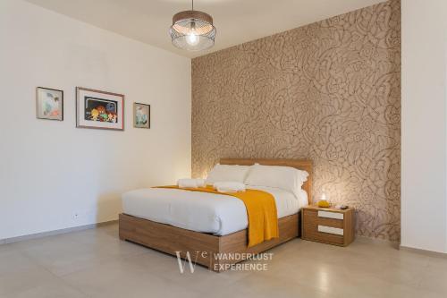 a bedroom with a bed and a wall at Wanderlust Experience Le dimore di Alice in Bitonto