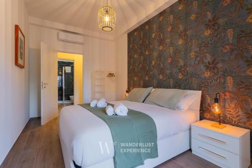 a bedroom with a large bed with towels on it at Wanderlust Experience Le dimore di Alice in Bitonto