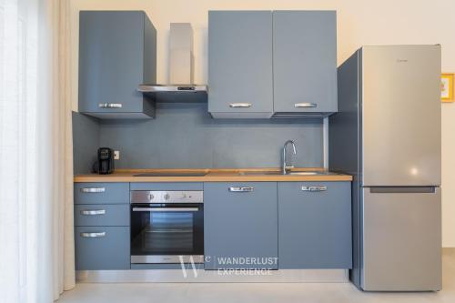 a kitchen with blue cabinets and a stainless steel refrigerator at Wanderlust Experience Le dimore di Alice in Bitonto