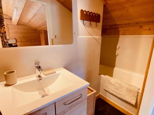 une salle de bain avec un lavabo et un miroir dans l'établissement Charmant 3 pièces savoyard avec balcon, cheminée, proche commerces et remontées mécaniques - FR-1-459-18, à La Clusaz