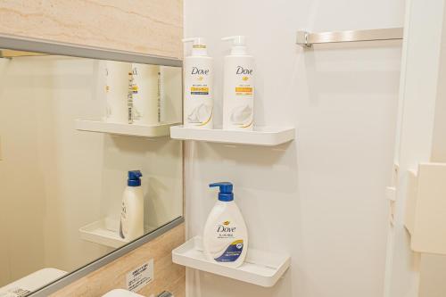a bathroom with white bottles of detergent on shelves at New 3-Story Japanese Villa, 5-Min Walk to Edogawa Sttion 7 Guests 76sqm Near Airport Kiyoka 清禾 in Tokyo
