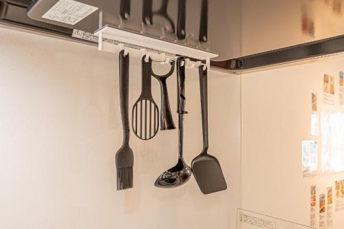 four kitchen utensils are hanging on a wall at New 3-Story Japanese Villa, 5-Min Walk to Edogawa Sttion 7 Guests 76sqm Near Airport Kiyoka 清禾 in Tokyo