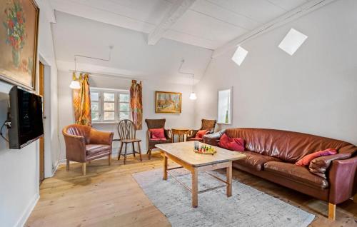 ein Wohnzimmer mit einer Ledercouch und einem Tisch in der Unterkunft 2 Bedroom Lovely Home In Blåvand in Blåvand