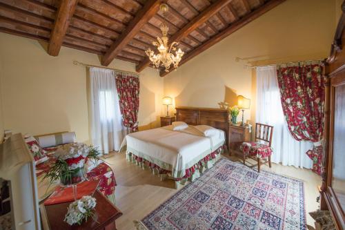 a bedroom with a bed and a chandelier at Hotel La Rescossa in Mira