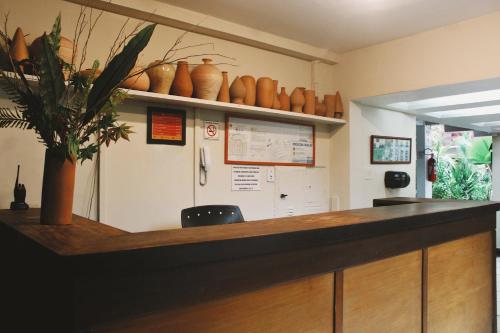 an office with a counter with vases on the wall at Hotel Pousada Del Rey in Macaé