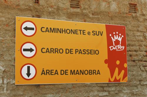 a yellow sign on the side of a brick wall at Hotel Pousada Del Rey in Macaé
