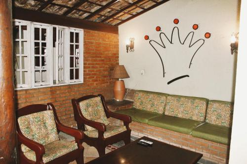a living room with a couch with a hand painted on the wall at Hotel Pousada Del Rey in Macaé