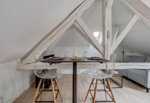 une salle à manger avec une table et deux tabourets dans l'établissement L'Atypique - Echappée sous les toits, à Toulouse