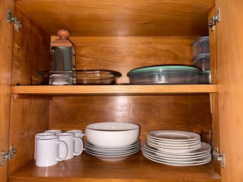 a wooden cabinet with plates and bowls and dishes at Apartamento con piscina, terraza y parking en las cercanías de Asunción in San Lorenzo