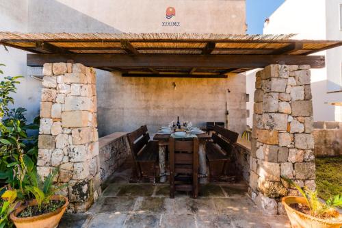an outdoor dining room with a wooden table and chairs at Villa Alida by Vivimy in Andrano