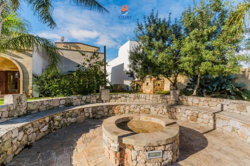 a stone retaining wall with a stone bench in a yard at Villa Alida by Vivimy in Andrano