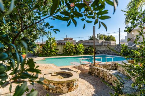 a swimming pool with a fire pit in a yard at Villa Alida by Vivimy in Andrano