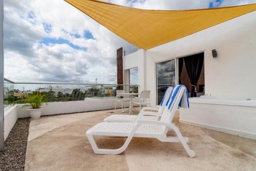 a pair of chairs on the balcony of a house at Cache Hotel Boutique - Adults Only in Playa del Carmen