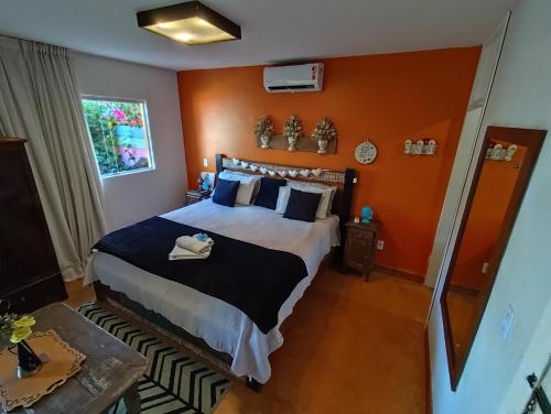 a bedroom with a large bed with an orange wall at Kabatukila Pousada in Natal