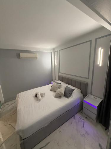 une chambre avec un lit avec des draps blancs et des oreillers dans l'établissement Apartment best position croisette martinez ! 150m from the beach completely renovated !, à Cannes