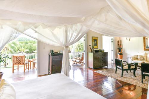 a bedroom with a bed with a white canopy at The Inn at English Harbour in English Harbour Town