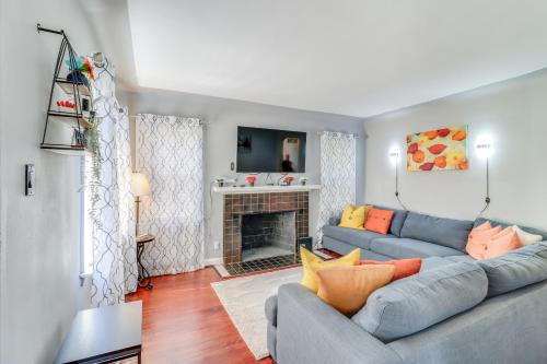a living room with a blue couch and a fireplace at Peaceful Detroit Home with Yard 10 Mi to Downtown! in Detroit
