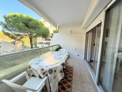 une pièce avec une table et des chaises sur un balcon dans l'établissement COSY APPART LE COUCHANT 4 Pers - CLIM, BALCON,PISCINE,PLAGE 5 MIN, LA GRANDE MOTTE, à La Grande Motte