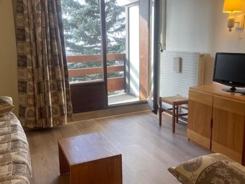 un salon avec une télévision et une grande fenêtre dans l'établissement Appartement cosy 2 pièces, 5 pers, balcon, wifi, animaux admis, quartier Croisette - FR-1-574-68, aux Menuires