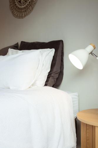 a bed with white sheets and a lamp on a table at Mount Hutt Haven in Methven