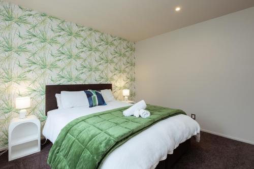 a bedroom with a large bed with a green blanket at Mount Hutt Haven in Methven