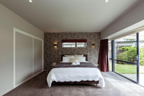 a bedroom with a bed and a large window at Mount Hutt Haven in Methven