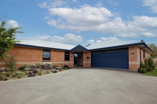 a large brick house with a blue garage at Mount Hutt Haven in Methven