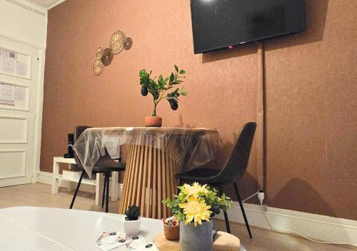 une salle à manger avec une table avec des chaises et une télévision dans l'établissement Le #2 Terracotta - Hypercentre, à Tours