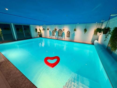 a swimming pool with a heart in the water at B&B Wellness Soest in Soest
