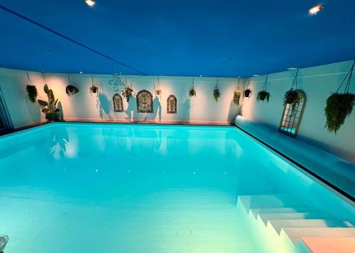a large swimming pool with blue water in a building at B&B Wellness Soest in Soest