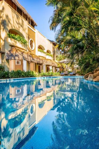 a swimming pool at a resort with palm trees at Casa Real Sayulita Hotel Boutique in Sayulita
