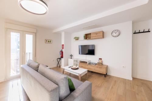 a living room with a couch and a tv at Jardinillos Bed & Parking in Jaén