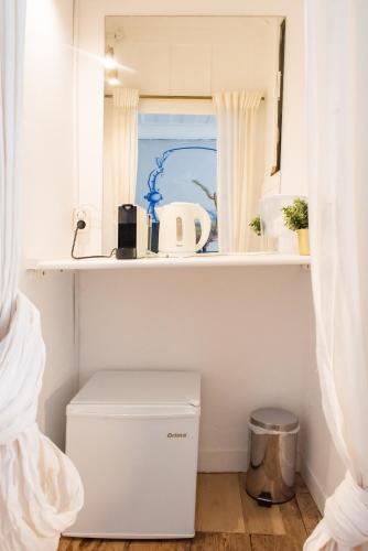 a small bathroom with a toilet and a window at Central Studio Suite - Ericeira in Ericeira
