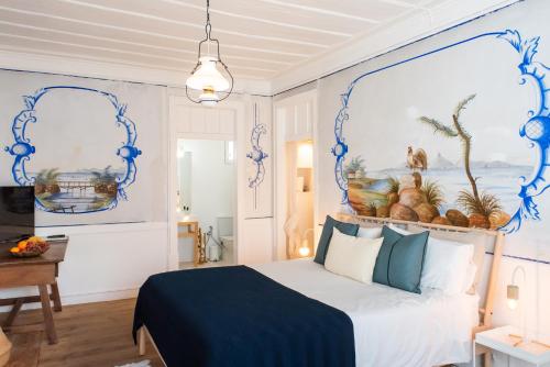 a bedroom with a bed with blue and white walls at Central Studio Suite - Ericeira in Ericeira