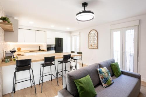 a living room with a couch and a kitchen at Jardinillos Bed & Parking in Jaén
