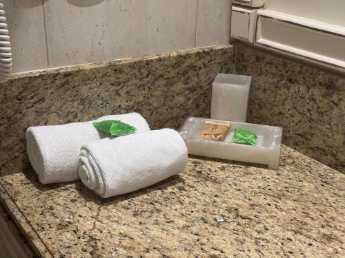 un bancone del bagno con asciugamani e una candela di Destino Floripa Jurerê In a Florianópolis