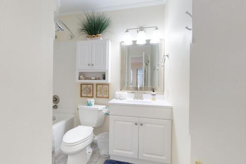 a bathroom with a toilet and a sink and a mirror at Spa on Port Royal Sound 3121 in Hilton Head Island
