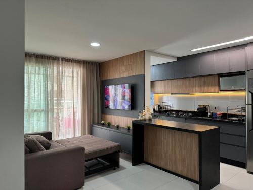 a living room with a couch and a kitchen at Summer Holiday com Piscina Climatizada - Piçarras in Piçarras