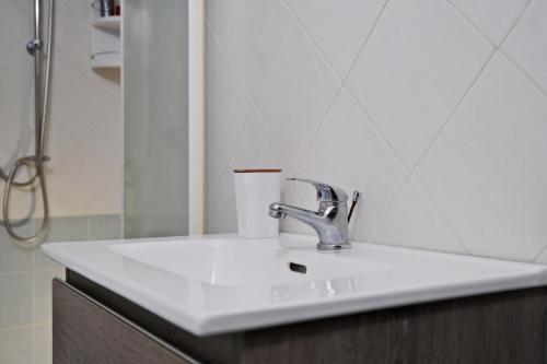a bathroom sink with a cup on it at La Veranda Sul Mare Sardegna - Baia delle Mimose in Badesi