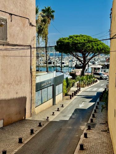 Une rue vide avec un arbre sur le côté d'un bâtiment dans l'établissement Le balcon de Bandol, à Bandol